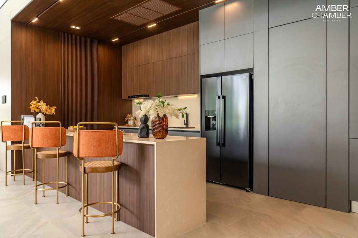 Amber Essence kitchen island with bar stools and dark cabinetry