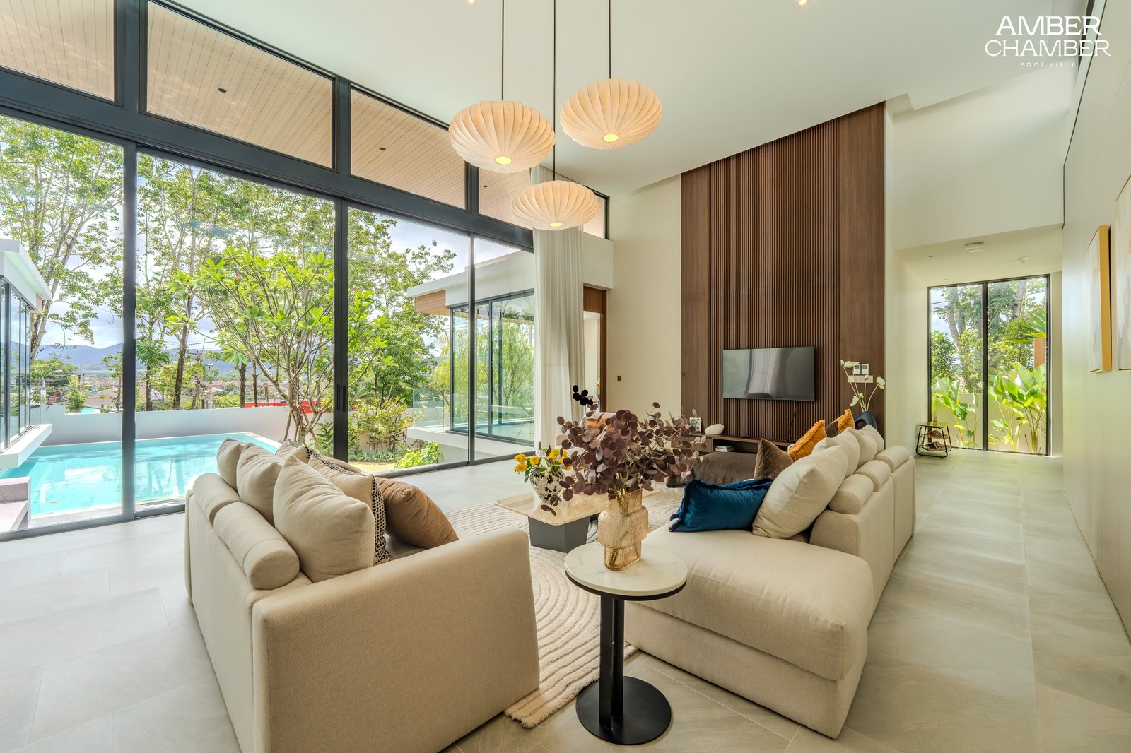 Villa living room opening onto the pool terrace through full-height sliding glazing